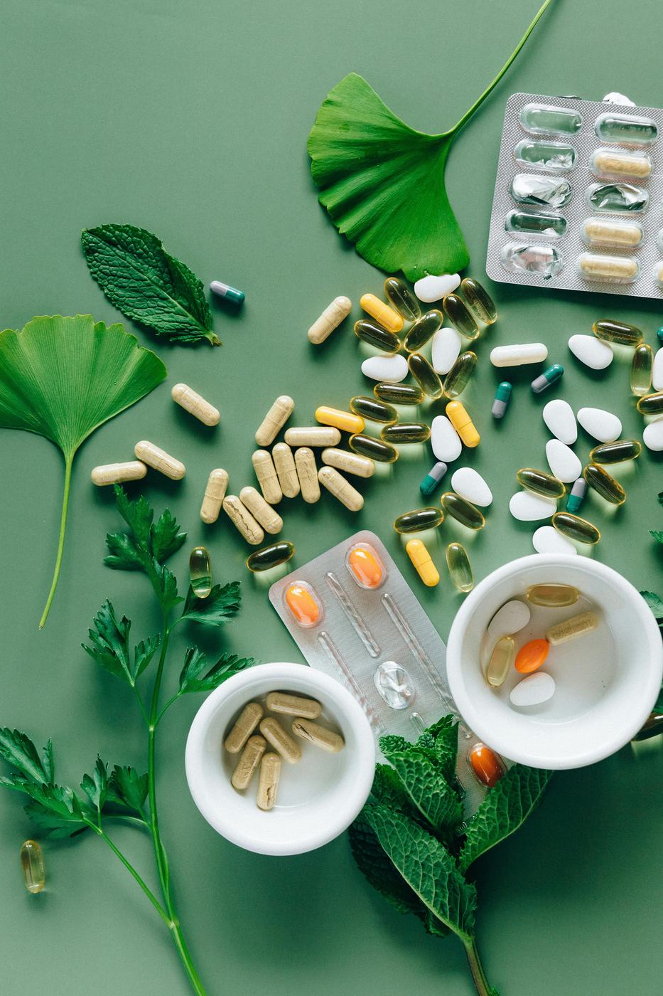 Capsules, tablets and green leaves